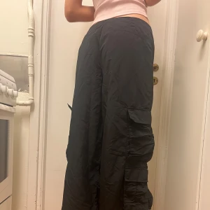 Svarta Byxor - Säljer mina svarta cargo pants! Lågmidjade, långa i benen (jag är 180cm), superfina! 💖 Fraktar/Möts upp i Solna. Kolla min profil för mer kläder <3 Paketpris gäller! 