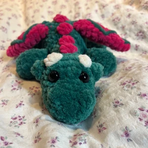 Drake vattenmelon - Två till virkade drakar, denna är i färgen ”vattenmelon”, superhärlig färgkombo🤩🩷💚 !Dessa innehåller säkerhetsögon som inte rekommenderas för barn under 3 år!