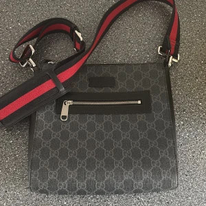  axelväska med GG-mönster - Säljer nu min svarta axelväska med mönster. Riktigt snygg och stilig. Passar med alla outfits. Den är som i nyskick.