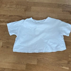 Vit croppad omlott-topp - Säljer en vit croppad topp från mango i mjuk bomull. Toppen har korta ärmar och en snygg omlott-detalj baktill som ger en cool twist. Passar jättebra till en chill dag hemma eller en runda på gymmet 