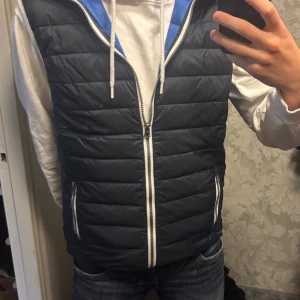 Mörkblå väst - Säljer min mörkblåa dunväst från East West. Den är i storlek M och har lite defekter i färg på baksidan, men som kan gå att tvättas bort. Skriv till mig vid funderingar!