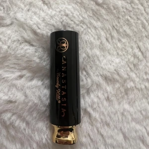 Anastasia Beverly Hills läppstift SARAINE - Läppstift från Anastasia Beverly Hills i nyansen SARAINE. Snygg metallisk röd färg med skimmer, klassisk hylsa i svart och guld. Perfekt för dig som vill ha ett statement på läpparna. Lyxig känsla och ikonisk design.