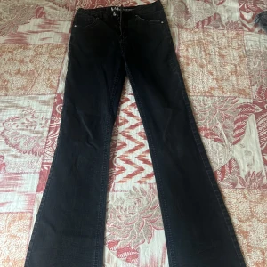 Svarta bootcut jeans från KappAhl  - Svarta jeans från LAB Industries med klassisk femficksdesign och bootcut-ben. Jeansen har hög midja och är tillverkade i ett jeansmaterial som ger en snygg siluett. Perfekta för dig som gillar en tidlös och stilren look.