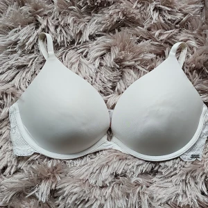 Vit bh med spetsdetaljer Hunkemöller  - Säljer en vit bh med avtagbara axelband som kan bäras på flera sätt, perfekt under toppar med bar axel. Bh:n har släta kupor och fina spetsdetaljer längs sidorna för en extra snygg touch. Mjuk och bekväm passform. Använt 2 gånger.   Strl 80B