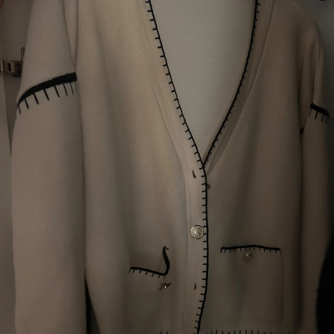 Beige kofta med svarta detaljer