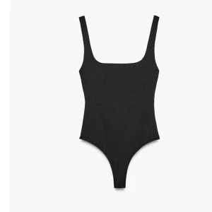 Svart ärmlös bodysuit med fyrkantig ringning - Säljer en svart, tight bodysuit med breda axelband och fyrkantig ringning fram. Bodyn har en enkel och clean design, perfekt att styla med jeans eller kjol. Materialet är stretchigt och följsamt för en snygg passform.