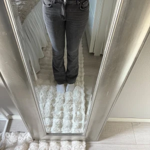 Grå bootcut jeans från Gina tricot - Snygga grå jeans från Gina tricot i bootcut-modell. Jeansen har klassisk femficksdesign, normal passform och är tillverkade i bomull. Perfekta för dig som gillar en stilren look med lite utsvängda ben.