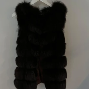 Svart pälsväst - Säljer en svart pälsväst i väldigt fint skick. Perfekt för dig som vill sticka ut med en lyxig och trendig stil. XS-S i storlek.