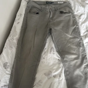 Gråa jeans från Cars Jeans 30/32 - Snygga gråa jeans från Cars Jeans i regular fit. Klassisk femficksmodell med raka ben och bälteshällor. Jeansen har en stilren look och passar perfekt till en avslappnad streetstyle. Materialet är mjukt och bekvämt, perfekt för vardagsbruk.