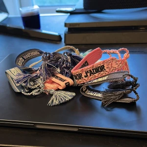 Christian Dior Armand, 100 kr styck skriv i dm  - Flera snygga armband från Christian Dior i olika färger som blått, rosa och grått. Broderade med texten 'Christian Dior' och 'J'Adior', med flätade band och tofsar i matchande färger. Perfekt accessoar för att lyfta din outfit med en lyxig touch.