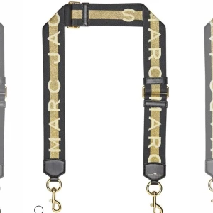 Axelrem från Marc Jacobs i svart och guld - Cool axelrem från Marc Jacobs i svart med bred guldig rand och stora bokstäver. Remmen har justerbar längd, guldfärgade metalldetaljer och läderdetaljer vid fästena. Perfekt för att ge din väska en personlig touch. Använd fåtal gånger. 