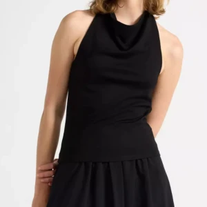 Svart halterneck linnetopp - Säljer en svart halterneck linnetopp med snygg drapering framtill och öppen rygg. Toppen är ärmlös och har en stilren, tight passform som sitter snyggt mot kroppen. Perfekt att matcha med kjol eller jeans för en cool look.