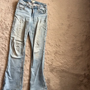 Ljusblå bootcut jeans från Gina Tricot - Snygga ljusblå jeans från Gina Tricot i klassisk bootcut-modell. Jeansen har dragkedja och knapp framtill.