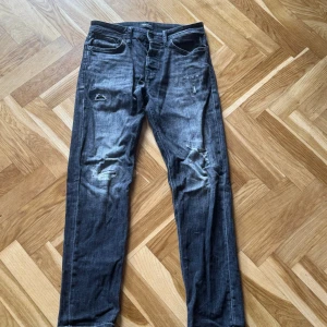 Jack and Jones mörkgrå slitna jeans straight fit - Säljer ett par mörkgrå jeans från Jack and Jones (Mike Tapered fit) med slitna detaljer och lagningar på knäna.