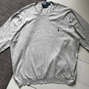 Grå Ralph Lauren Stickad Tröja - Riktigt snygg stickad Ralph Lauren tröja perfekt nu till vinter. | Nypris: 1699kr | Storlek: XL men sitter som M. | Mycket bra skick, förutom att i nacken sitter lite löst. | Pris ej hugget i sten skriv vid minsta fundering!