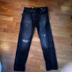 Svarta jeans - Snygga svarta jeans med slitningar på framsidan. Mike tapered. W30 L32