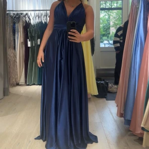 Marinblå balklänning - Säljer min superfina balklänning med v-ringning, då jag inte har användning för den längre. Perfekt för studentbalen! Uppsydd för mig som är 167cm lång, använde klackar med ca 7cm klack. I strlk 10, köpt i butik på Ivory field i stockholm. Köpt för 3 100. Säljer för 1799.