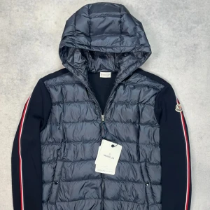 Moncler hooded cardigan jacket - – Condition: 10/10 - brand new with tags  - Size: XL  – Retail price: 10 000 + SEK  Please note that Moncler runs small, we recommend going up one size from your usual size.