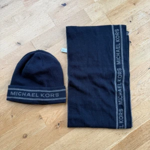 Mössa & Halsduk från Michael Kors - Svart set från Michael Kors med mörkgrå logga längs kanten