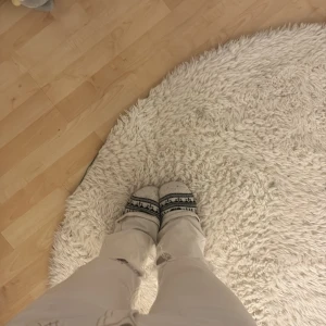 Vita bootcut jeans med slitningar - Säljer ett par vita bootcut jeans med snygga slitningar vid knäna och kontrastsömmar. Jeansen har klassisk femficksdesign och låg midja. Perfekta för dig som vill ha en clean look med lite edge.liten fläck på ena fickan men inget man tänker på och går säkert bort efter nån tvätt.pris kan diskuteras.litet hål på byxan längst längst ner vid slutet av benet