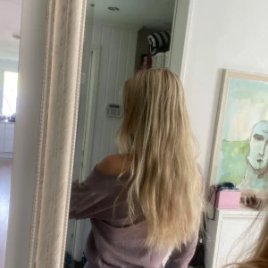 Ljuslila glittrig tröja - Superfin ljuslila tröja med glittrigt tyg och offshoulder-passform om man vill. Tröjan har långa ärmar, ribbade muddar och sitter snyggt på kroppen. Perfekt om du vill ha en lite extra touch till din outfit.