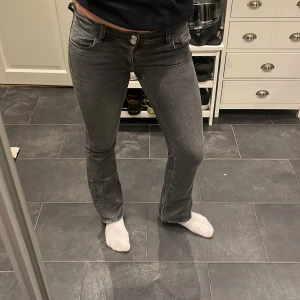 Grå bootcut jeans från Gina Tricot - Säljer mina lågmidjade bootcut jeans då de är för små. Saknar en knapp på ena bakfickan men är annars i bra skick🥰