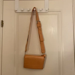 Orange axelväska  - Jätte fin orange väska från Carin Wester. Passar perfekt till våren med den pastrlugs färgen. 