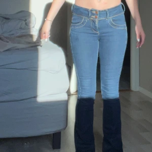 Bootcut jeans från Jasper Conran - Snygga blå bootcut jeans från Jasper Conran med klassiska fickor bak och fram, dubbla knappar i midjan och kontrastsömmar. Jeansen har en låg  midja och är tillverkade i stretchigt denim för en bekväm passform.