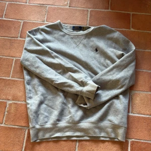 Grå sweatshirt från Polo Ralph Lauren - Klassisk grå sweatshirt från Polo Ralph Lauren, den är i storleken L men passar även M
