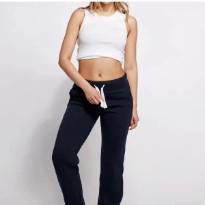 Mörkblå mjukisbyxor - Mörkblå mjukisbyxor med vit snörning i midjan. Byxorna har en avslappnad passform och är perfekta för chill dagar. Tillverkade i mjukt material som känns skönt mot huden.