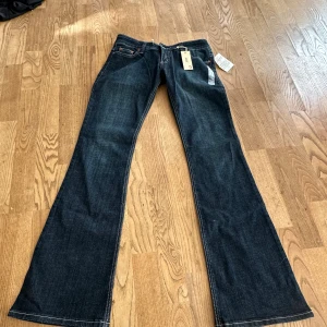 Super low bootcut guess jeans  - Säljer ett par väldigt lågmidjade helt nya jeans från guess. De breda nertill och strechiga. Midjemåttet platt är 38cm och innerbenslängden är 84cm.                                  Det är bara att höra av sig vid frågor!💕