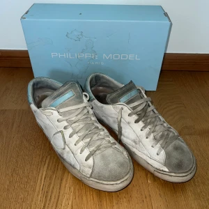 Vita sneakers - Philippe Model - Feta philippe modell skor som är rätt så använda. Inga hål eller stora skador på skorna. Dem har mycke liv kvar men är billigt på grund av smutset. Äkta. Vid mer frågor är det bara att skriva!!!