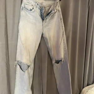 Ljusblå ripped jeans från g perfect jeans - Ljusblå jeans med slitna hål på båda knäna från g perfect jeans. Klassisk femficksmodell med raka ben och hög midja. Jeansen är i denim med snyggt tvättad look och råa kanter vid hålen för en trendig vibe.
