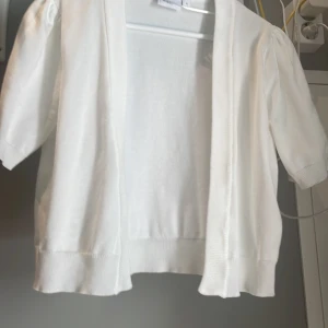 Vit kofta från Saint Tropez - Snygg vit kofta från Saint Tropez i storlek S. Modellen är öppen framtill, har korta puffärmar och ribbade kanter. ⚠️endast använd 1 gång!⚠️köpte för mycket mer!