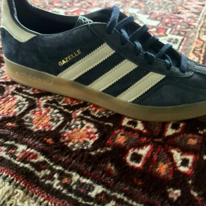 Adidas Gazelle mörkblå sneakers mocka - Säljer AdidasGazelle indoor i mörkblå mocka,Perfekta för hösten och våren och för dig som gillar retrostil och streetwear. Nästan helt nya