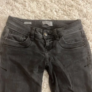 Svarta bootcut jeans från LTB - Säljer ett par svarta jeans från LTB, modell Valerie. Jeansen har klassisk femficksdesign, svarta sömmar och bootcut-ben. Materialet är jeans och färgen har en lätt tvättad look. Perfekta för dig som gillar en tidlös och snygg stil. Storlek 25/32