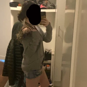 Kofta med fuskpäls  - Jättefin stickad kofta med fuskpäls på luvan. Köpt på Plick. Defekter: en knapp i mitten är borta men det syns knappast. Pris kan diskuterad.