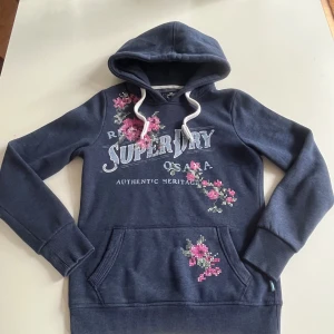 Superdry Hoodie strl XS - Säljer denna feta Superdry hoodie i strl XS. Tröjan är i väldigt fint skick, utan defekter. Den är varm och perfekt till hösten och vintern. Hör av er vid minsta fundering!😁