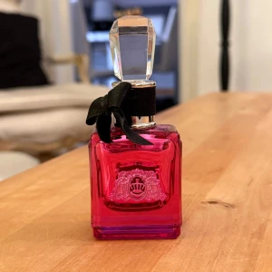 Viva La Juicy Noir parfym - En lyxig parfymflaska i mörkrosa glas med silverdetaljer och svart rosett runt halsen. Säljer pga det är inte min smak, finns ca 80% kvar. Luktar bärigt och vaniljigt! Passar både till vardags eller utekvällar.