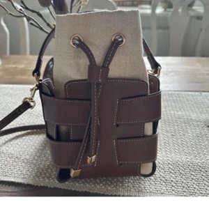 Brun och beige bucket bag med snörning - Funderar på att sälja min hm väska, välanvänd men bra skick fortfarande! Hör av er vid frågor och tryck INTE på köp nu!🧡🫶🏻