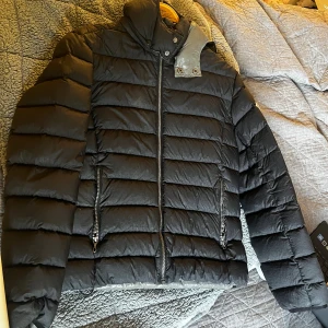 Svart Colmar pufferjacka  - Svart pufferjacka från Colmar med ett litet hål på ärmen men som är tejpad.