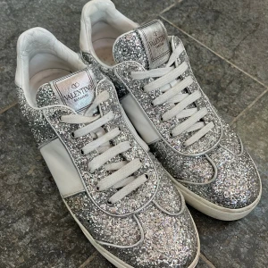 Valentino Flycrew glittriga  - Säljer mina silver glittriga Valentino Flycrews då de inte används! Storlek 39, mycket bra skick💕 Köpte dem nästan helt nya här på plick, dock så tillkom inte dustbag eller något. Har själv använt de endast 2 gånger. Tyvärr så har en nit på högra skon ramlat av men man lägger inte märke till det! Tveka inte att höra av dig om du har några frågor eller vill diskutera priset!💕