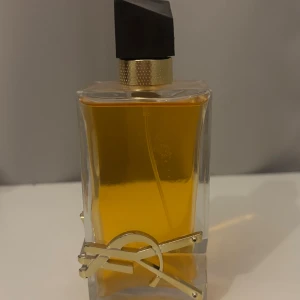 Trendig parfym med guldig detalj - Stilren parfym från Yves Saint Laurent med unik guldig detalj på flaskan.