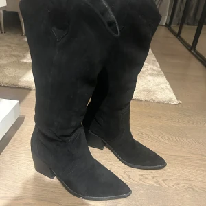 Svarta mocka cowboy boots med klack - Snygga svarta cowboy boots i mocka med spetsig tå och  klack. 