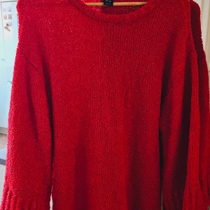 Röd stickad tröja med lång ärm - Säljer en röd stickad tröja med lång ärm och rund hals. Tröjan har en grovstickad struktur som ger en mysig och cool vibe. Perfekt för dig som gillar färg och vill ha något som sticker ut i garderoben.