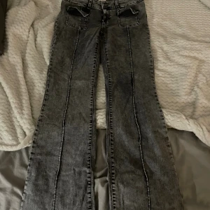 Bootcut jeans - Snygga bootcut jeans från Nelly i grå tvätt med fickor framtill. Modellenär tillverkad i stretchig och  skön passform. Storlek 42 