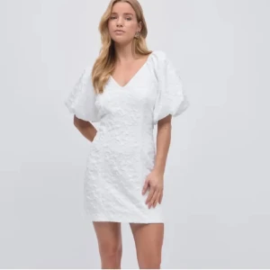 Vit kort klänning med puffärm - Superfin vit kort klänning med v-ringning och stora puffärmar. Andvänt 1 gång