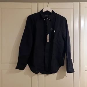 Ralph Lauren Skjorta - Helt ny Ralph Lauren skjorta i storlek M. Mörkblå med vit logga. För frågor, kontakta!