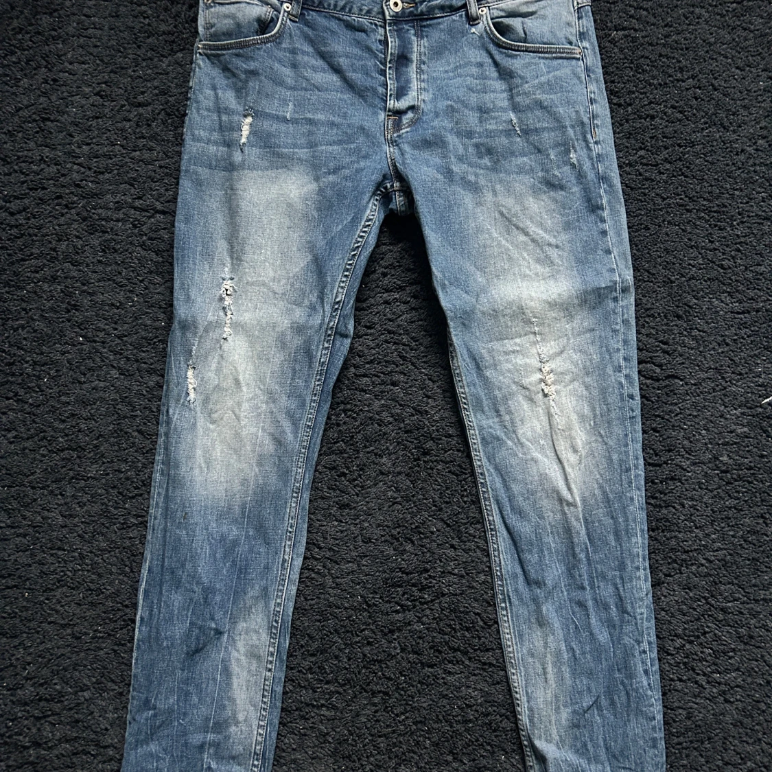 Blå baggy jeans med slitningar