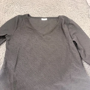 svart blommig långärmad tröja JDY - Snygg svart långärmad tröja från JDY i storlek S. Tröjan har ett blommigt mönster och v-ringad hals. Materialet är mjukt och bekvämt,